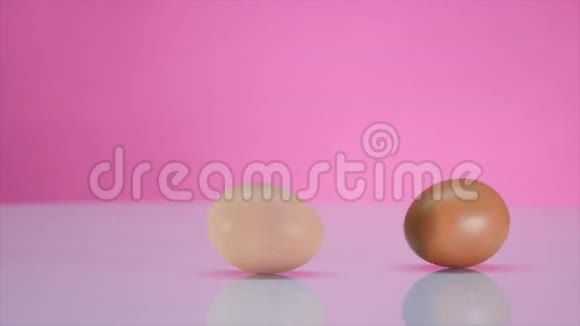 两个鸡蛋在粉红色背景的桌子上旋转视频的预览图