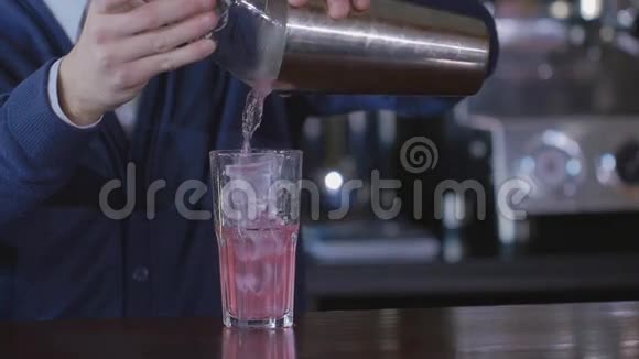 酒吧服务员用冰块和两种透明液体不寻常的玻璃杯中的甜糖浆来准备鸡尾酒饮料视频的预览图