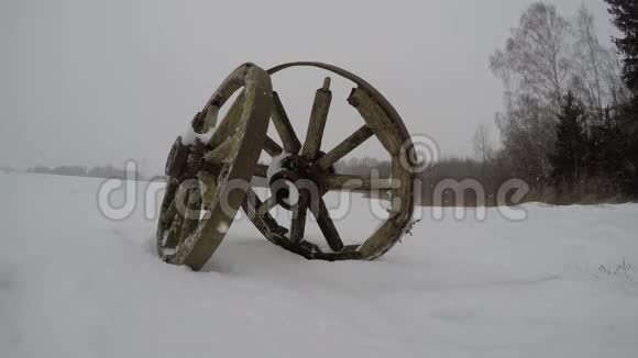 两辆古老的历史马车车轮在田野和冬季下雪时间流逝4K视频的预览图