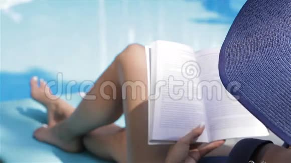 女人在游泳池附近翻书页视频的预览图