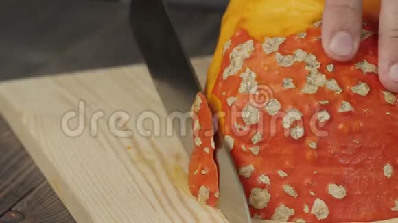 奶油南瓜汤烹饪健康食品刀把一个新鲜的橙色南瓜切成木桌上的切片快关门4K视频的预览图