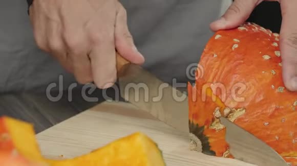奶油南瓜汤烹饪健康食品厨师在木桌上把一个新鲜的橙色南瓜切成薄片快关门4K视频的预览图