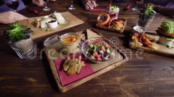 一张木制桌子的特写镜头上面有素菜小吃装饰精美由服务员端上来视频的预览图