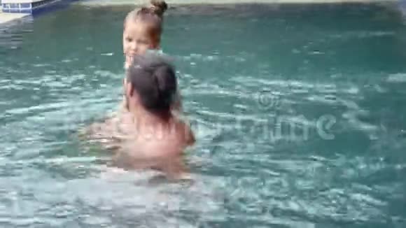 幸福的家庭活泼的父亲带着小孩子可爱的蹒跚学步的女儿在游泳池里玩得很开心视频的预览图