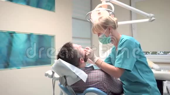 牙医检查病人的牙齿看着相机是的是的视频的预览图