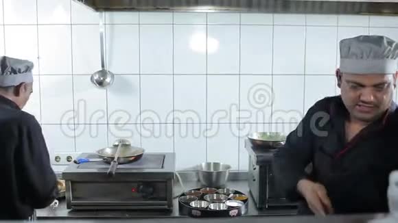 两个厨师在厨房餐厅准备饭菜视频的预览图
