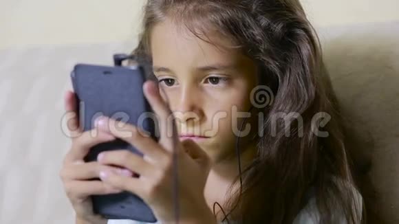 带着手机的女孩子浏览互联网耳机视频的预览图