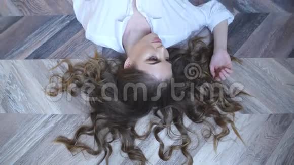 躺在地板上的美女正对着镜头摆姿势视频的预览图