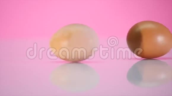 两个鸡蛋在粉红色背景的桌子上旋转视频的预览图