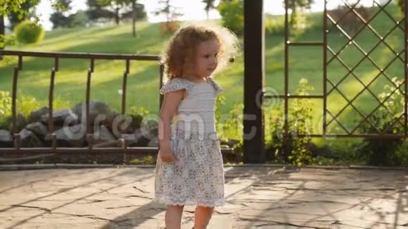 快乐的小卷曲女孩在公园里跑步慢速视频视频的预览图