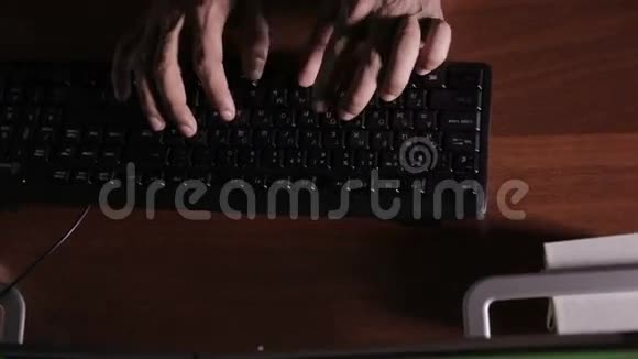 顶部视图在黑暗的房间里男人用手在键盘上打字黑客专业电脑专家视频的预览图