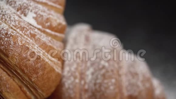 黑色背景上带有糖粉的美味牛角面包左侧幻灯片视频的预览图