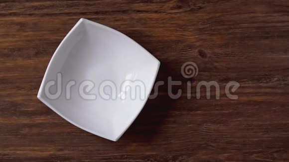 玉米片落在白色的碗里右边是木桌上的交叉空间视频的预览图