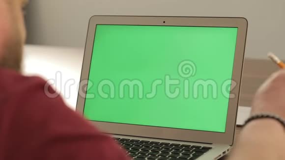 创意经理工作商业概念自信的年轻人在他的笔记本电脑上用彩色钥匙绿色屏幕视频的预览图