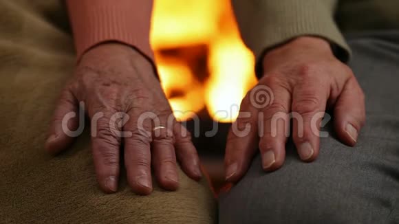 女人和男人的双手在壁炉前休息老年概念视频的预览图