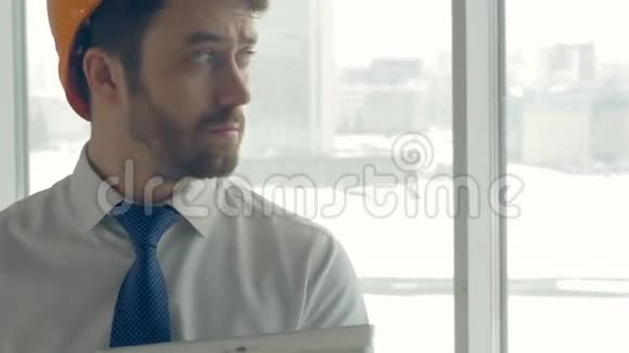 建筑大师戴安全帽的商人在一个建筑工地内用平板电脑检查施工进度滑块视频的预览图