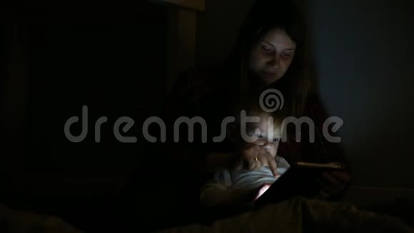 儿子和母亲在床上玩触摸垫游戏的特写镜头业余娱乐视频的预览图