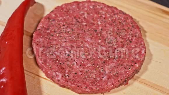 厨师为汉堡做肉奖章倒入香料胡椒和盐肉夹肉牛肉在食品木板上视频的预览图