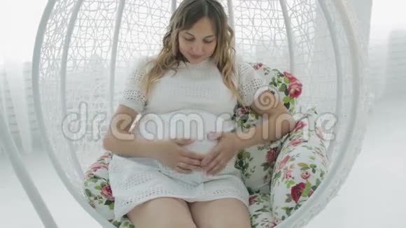 孕妇用心形的手握在怀孕的肚子上视频的预览图