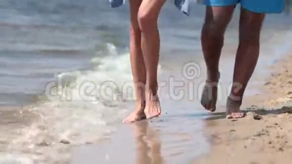 在海滩水边行走的特写双脚视频的预览图