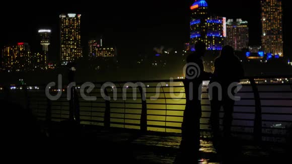 朋友亚洲男人和高加索女人在晚上谈论城市的背景它可以看到轮廓视频的预览图