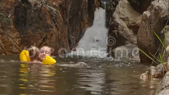 小金发女孩在瀑布边游泳视频的预览图