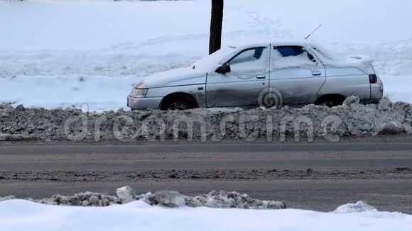 雪覆盖的汽车在雪道的一侧侧视视频的预览图