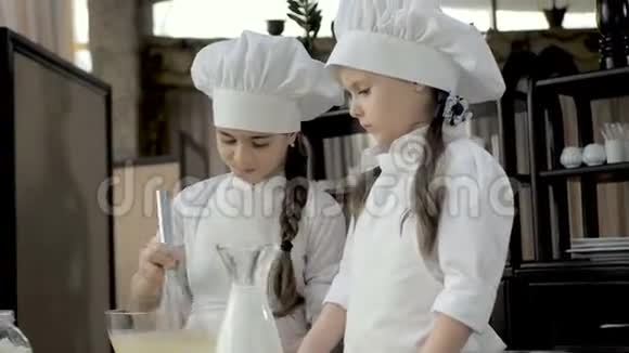 有趣的年轻女孩正在厨房里准备面团视频的预览图