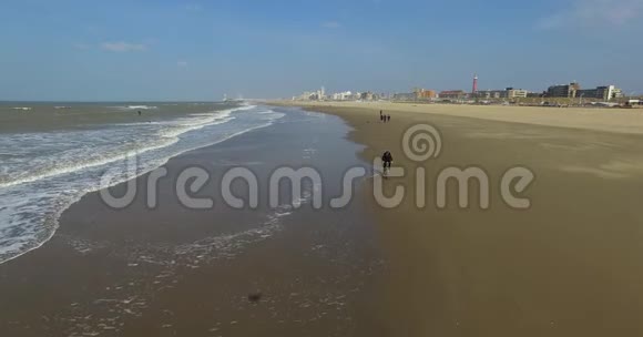 鸟瞰海岸线与人和白海浪无人机在荷兰海滩上飞行视频的预览图