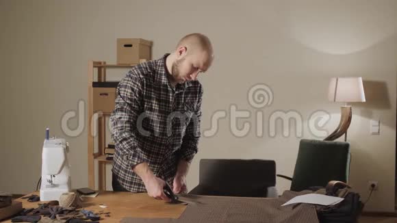 裁剪棕色格子毛织物线条图案年轻人做裁缝在车间里使用缝纫机视频的预览图