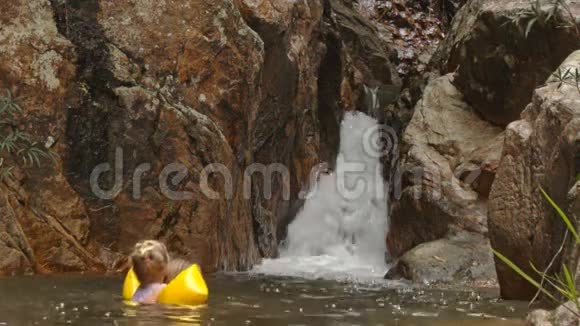 小金发女孩在瀑布边游泳视频的预览图