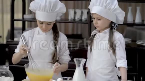 有趣的年轻女孩正在厨房里准备面团视频的预览图