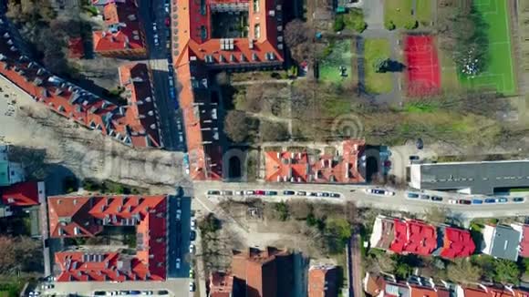 欧洲城市住宅区运动场的空中镜头和住宅建筑倾斜的平铺屋顶顶部视频的预览图