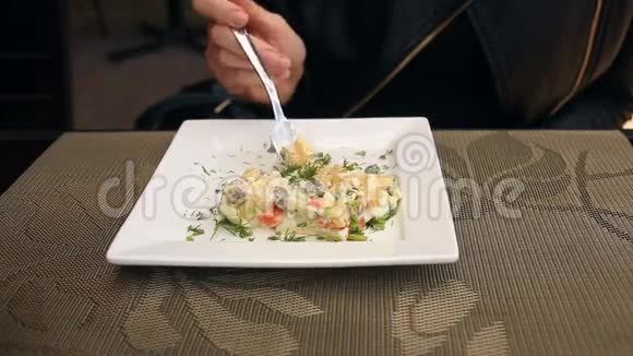 男人正在吃一个带有方形盘子的土豆沙拉特写视频的预览图