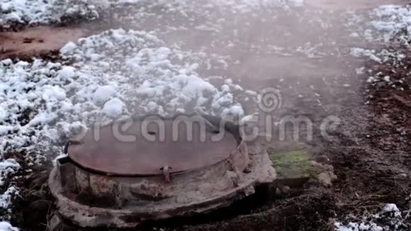 近距离蒸汽来自雪中的卫生下水道盖融化的雪视频的预览图