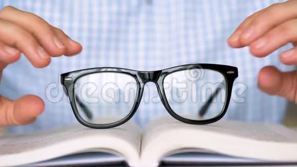 人拿着眼镜近距离地看一本书视频的预览图