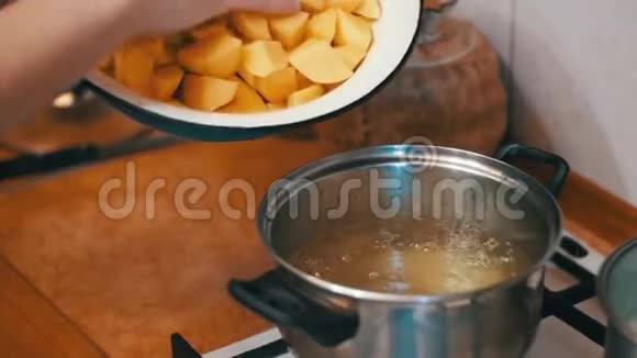 女厨师把切好的土豆放在锅里煮家庭厨房缓慢的动力视频的预览图