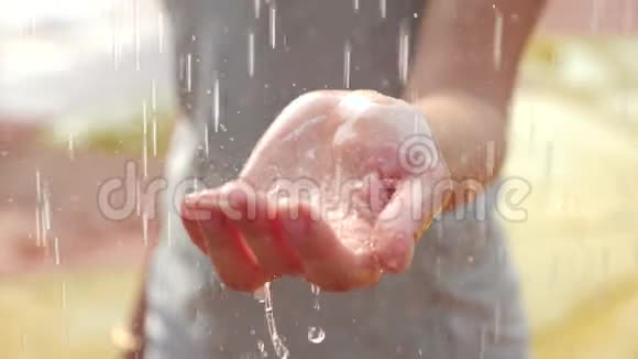 女人的手被大雨的水滴覆盖在特写4k慢镜头视频的预览图