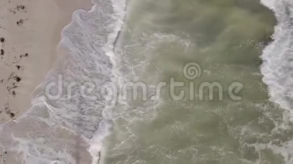 以海滩和海浪为背景的海岸线鸟瞰顶部视频的预览图