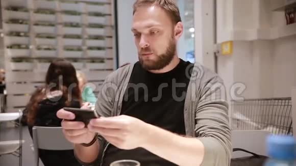 公共场所的现代技术有胡子的帅哥用智能手机视频的预览图
