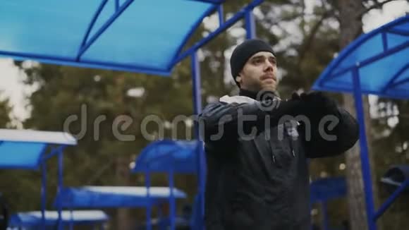 在冬季公园训练前做热身运动的帅哥视频的预览图