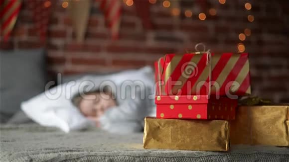 可爱的女孩睡在床上圣诞礼物站在她身边然后孩子醒来拿走你的礼物视频的预览图