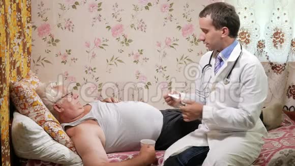 一个男医生在家里生病时给他吃药那人正在喝水躺在沙发上视频的预览图