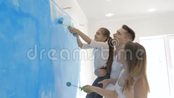 幸福的年轻家庭和小女儿画墙视频的预览图