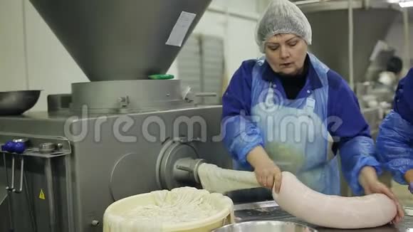 香肠的制作过程用碎肉填充肠道在肉类加工厂购物手举起来视频的预览图