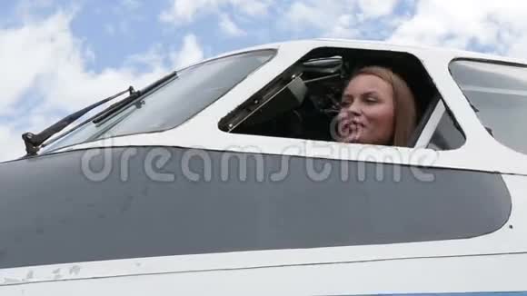 美丽的少女飞行员坐在飞机的操纵处望着窗外视频的预览图