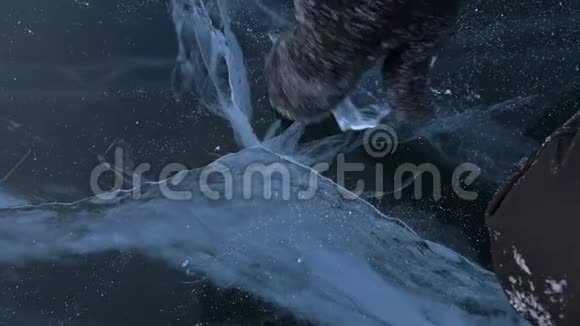 穿着手套的人在冰上扭冰慢动作相机在冰后移动一块冰真的视频的预览图