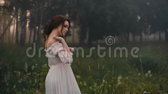 美丽的女孩穿着白色连衣裙在相机上摆姿势视频的预览图