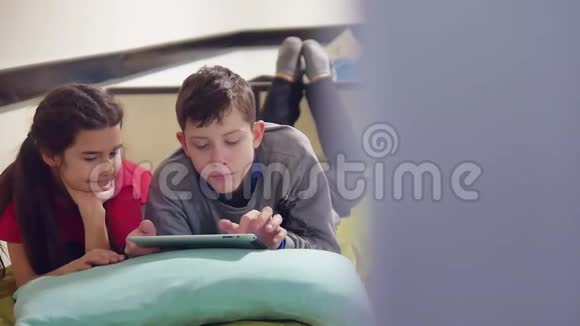 男孩和女孩在玩平板电脑兄妹儿童社交媒体网络游戏室内平板电脑视频的预览图