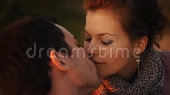 在橙色夕阳下亲吻情侣的剪影视频的预览图